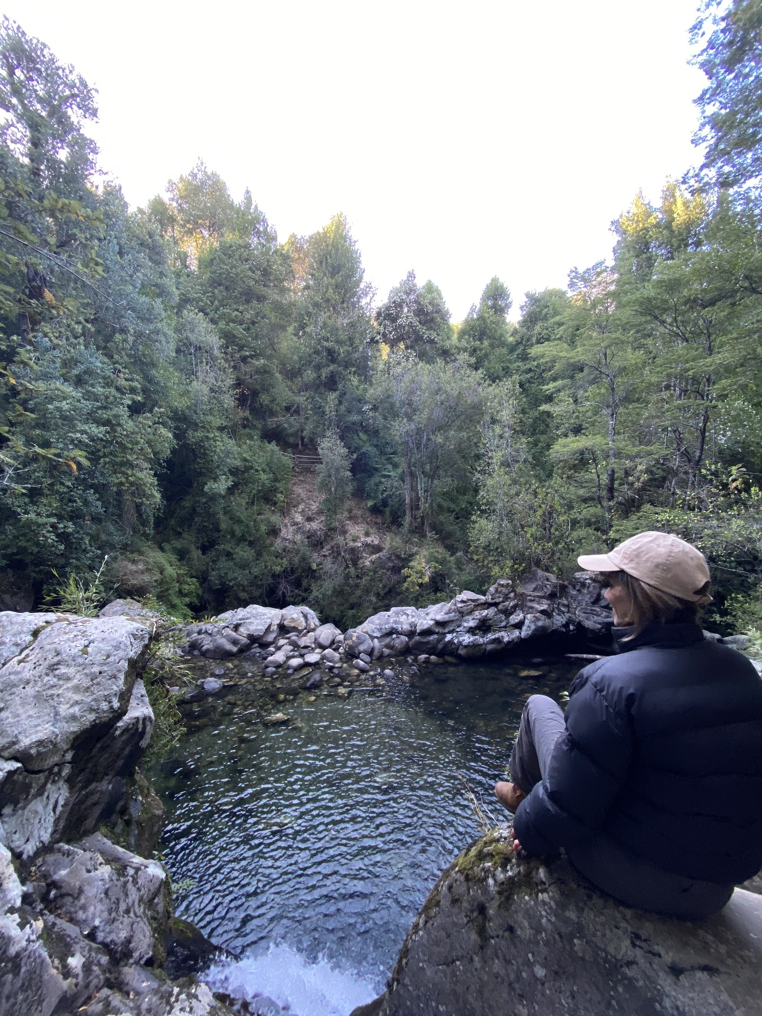 mujer sobre roca y rio aurora loft pucon