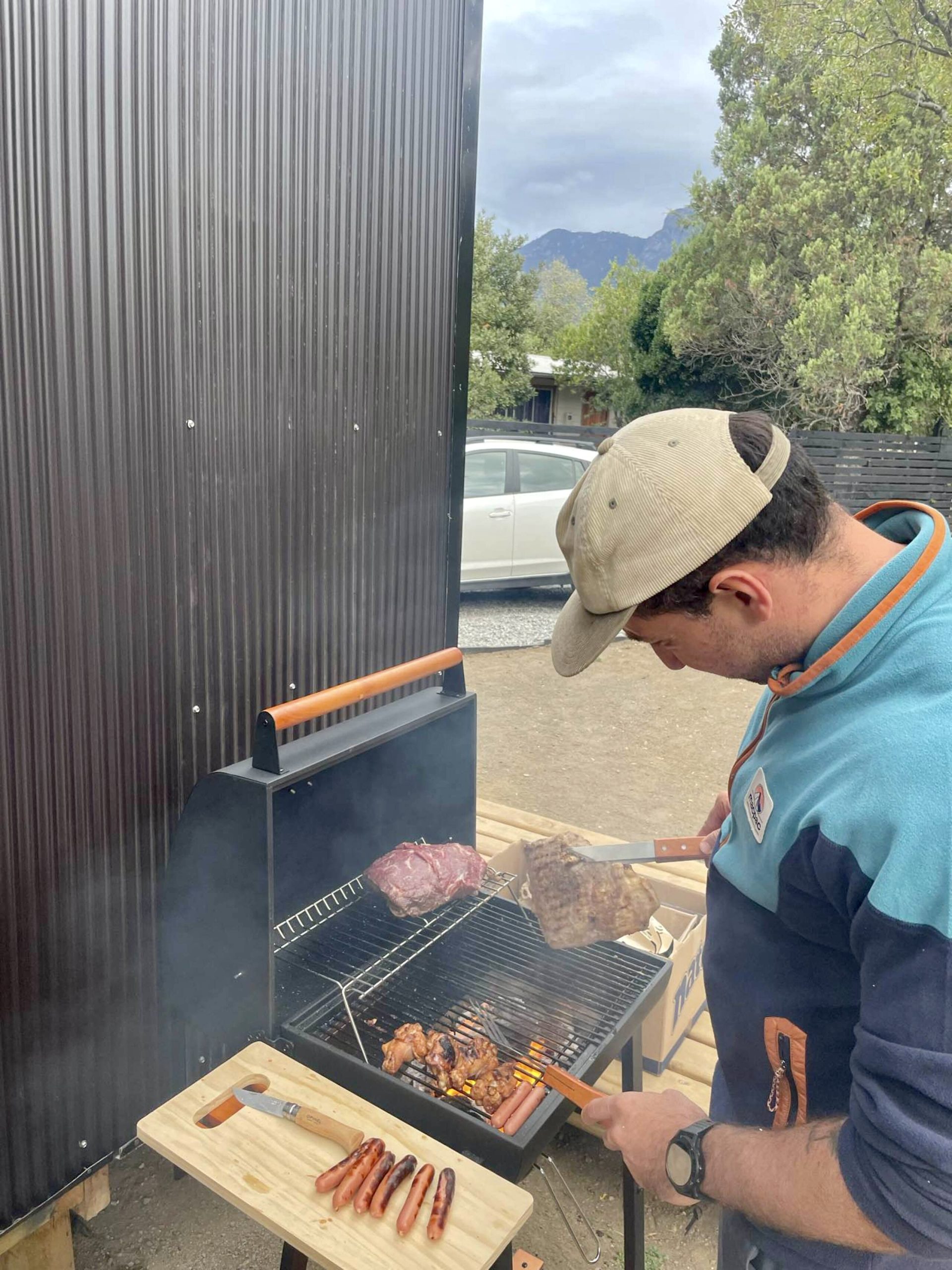 hombre asando carne en asadera aurora loft pucon