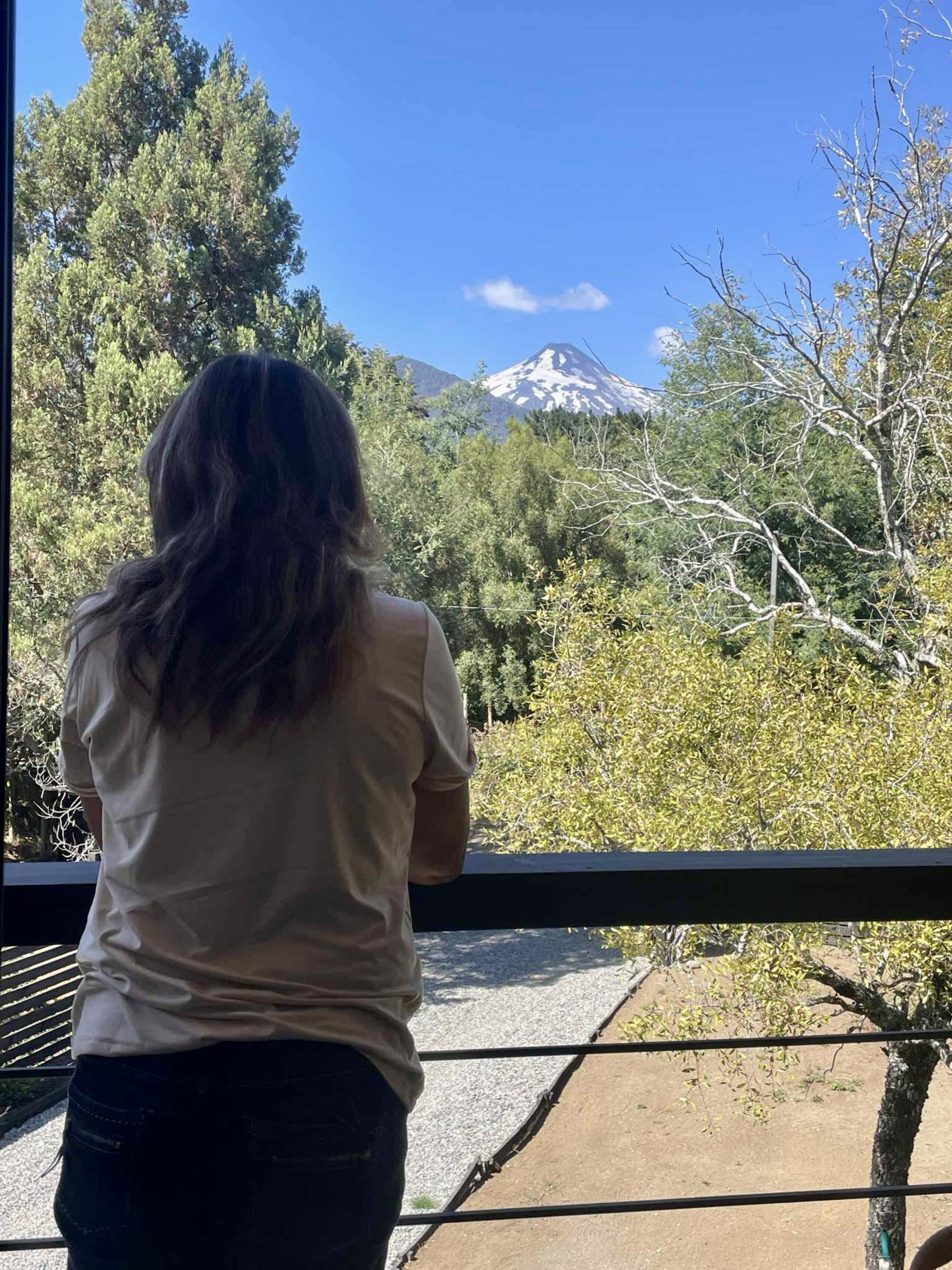 mujer viendo volcan desde aurora loft pucon